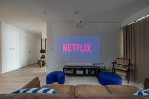 a living room with a netflix sign on the wall at Waterview apartments with ultra fast wifi close to Excel and O2, corporates and contractors welcome in London
