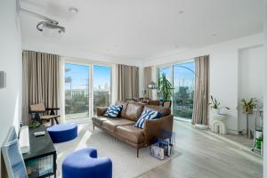 a living room with a couch and a large window at Waterview apartments with ultra fast wifi close to Excel and O2, corporates and contractors welcome in London