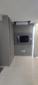 Camera con parete, finestra e TV. di Loft casa 203 COND BRISAS DO FAROL n 07 a Salvador