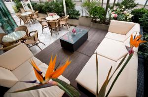 a patio with white furniture and a table and chairs at Hotel Kennedy in Rimini