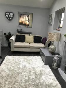 un salon avec un canapé et un tapis dans l'établissement Sefton Cottage, à Ormskirk