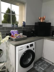 une cuisine avec une machine à laver sur un comptoir dans l'établissement Sefton Cottage, à Ormskirk 4 autres photos