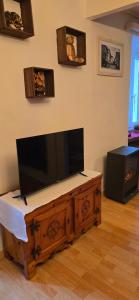 Ein Flachbildfernseher steht auf einem hölzernen Unterhaltungsmöbel. in der Unterkunft Namastè Ca Biasca in Biasca