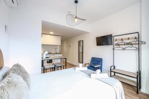 a bedroom with a white bed and a blue chair at Elegant Studio with Private Terrace by RentitUP in San Sebastián de los Reyes