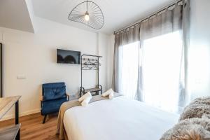 a bedroom with a white bed and a blue chair at Elegant Studio with Private Terrace by RentitUP in San Sebastián de los Reyes +12 photos