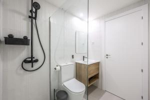 a white bathroom with a shower and a toilet at Elegant Studio with Private Terrace by RentitUP in San Sebastián de los Reyes