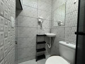 a small bathroom with a toilet and a sink at Ático com Ar Condicionado Q e F in Ponta Grossa +59 photos