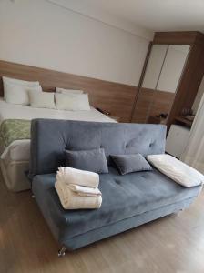 Sofá azul en una habitación con cama en Vista Azul Apart Hotel - Pedra Azul com Vista Pinheiros, en Pedra Azul