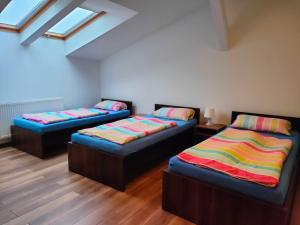 a room with two beds with colorful blankets at Pokoje Gościnne pod Dębem in Popielów
