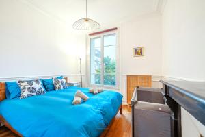 een grote blauwe bank in een kamer met een raam bij L'Escale Parisienne Charmant T2 proche métro et Paris in Pantin +4 foto's