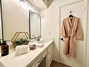 孔洛King Bed Suite in Conroe , Garage Available的浴室设有水槽,门上设有浴袍 更多37张照片