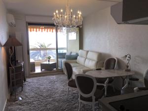 uma sala de estar com um sofá e uma mesa em Dionysos Vue Mer em Cannes