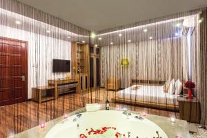 baño con bañera, cama y TV en Valentine Hotel, en Ho Chi Minh