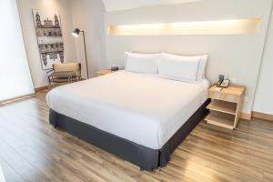 une chambre avec un lit, une table et une chaise dans l'établissement Sonesta Hotel Bogotá, à Bogotá