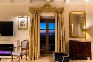 a living room with a window and a mirror at The Xara Palace Relais & Chateaux in Mdina