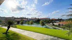a park with a river in front of a building at Flat 602 - Villa Hípica Flat & Club - Gravatá in Gravatá