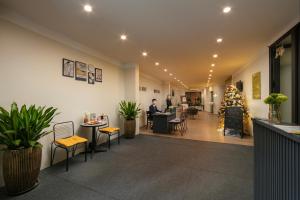 a lobby with a christmas tree and people sitting at tables at Westlake Pearl Apartment - Hotel & Pearl Spa in Hanoi