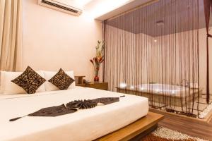 ein Schlafzimmer mit einem Bett und einer Badewanne im Fenster in der Unterkunft Valentine Hotel in Ho-Chi-Minh-Stadt