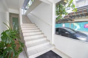 eine Treppe in einem Haus mit einem Auto im Fenster in der Unterkunft JOA22 - 1 Suíte, TV Smart, Aconchegante, Garagem in Balneário Camboriú