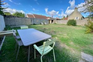 a picnic table and chairs in a yard at La Casa Plume proche du centre et de la mer in Hermanville-sur-Mer