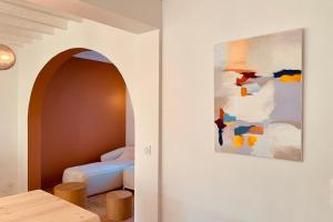 a room with a bed and a painting on the wall at La Casa Plume proche du centre et de la mer in Hermanville-sur-Mer +4 photos