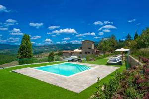 パンツァーノにあるMy Exclusive Italy - Chianti's Villa with vineyard, infinity pool & viewの芝生の真ん中に家があるプール
