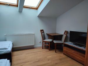 a room with a desk and a table with a laptop at Pokoje Gościnne pod Dębem in Popielów