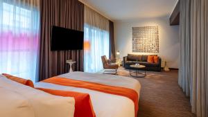 a hotel room with a bed and a couch at east Hotel Hamburg in Hamburg