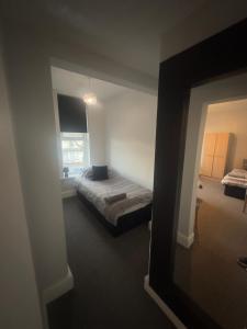 a bedroom with a bed in a room with a mirror at The Prince Alfred Rooms in Liverpool