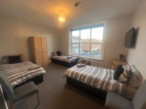 a hotel room with two beds and a window at The Prince Alfred Rooms in Liverpool