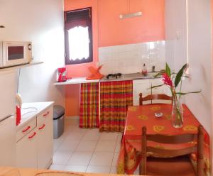 a kitchen with a table with a vase on it at Studio cosy à Capesterre Belle Eau 24 m² avec jardin privé in Capesterre-Belle-Eau