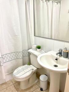 a white bathroom with a toilet and a sink at Departamento 2D en Iquique!!! in Iquique