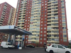 a gas station with cars parked in front of tall buildings at Departamento 2D en Iquique!!! in Iquique