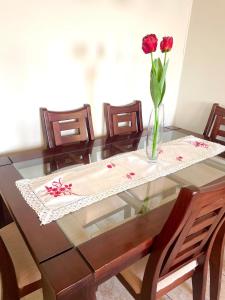 a glass table with a vase of flowers on it at Departamento 2D en Iquique!!! in Iquique +10 photos