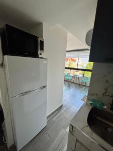 a kitchen with a microwave on top of a refrigerator at SUITE INTI vista al mar in Acapulco