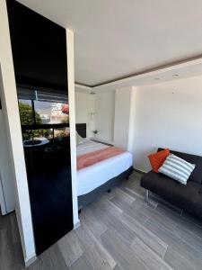 a bedroom with a bed and a couch in a room at SUITE INTI vista al mar in Acapulco