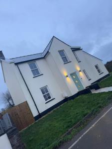 a white house with lights on the front of it at 3 Bedroom Holiday home with Hot Tub in Carew