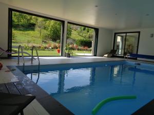 Una gran piscina con agua azul en una casa. en Villa La Bénéchie, en Castang