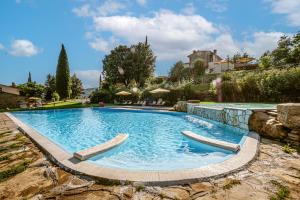 a large swimming pool with two chairs in a yard at Agriturismo Borgo Sant'Ercolano in Ciggiano