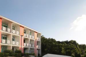 an apartment building with balconies and trees in the background at Bay Room in Les Trois-Îlets