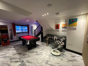 a living room with a pool table and a couch at The Secret Agent Apartment - Brought to you by Coastline Retreats - Brand New - 2 mins walk to Beach - Childrens play den - Pool Table - Time Crisis Arcade Machine in Southbourne