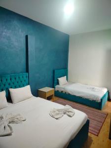 a bedroom with two beds and a blue wall at Anubis kingdom pyramids view in Cairo +81 photos