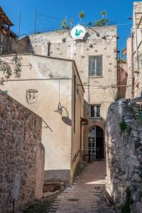 an alley with a building with a sign on it at Casa del Teatro in Borgio Verezzi