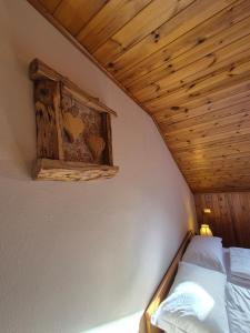 een bed in een kamer met een houten plafond bij La Casa del Mulino in Pozza di Fassa