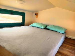 a bedroom with a bed with two pillows on it at Tiny Haus Komos in Pitsidia