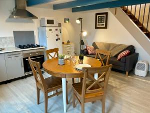 a kitchen and a dining room with a table and chairs at La Roserie in Auderville