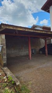 un garage coperto con un'auto parcheggiata sotto di Studio Marangoni Hospedaria Apartamento 2 a Treze Tílias