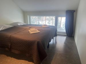 a bedroom with a bed with two towels on it at B2 Lakeside Suite Polku Hotel in Vihti