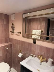 une salle de bain avec un lavabo et un miroir dans l'établissement Stunning Cotswolds Cottage 5 min from Soho Farmhouse, à Enstone