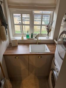 une cuisine avec un évier et une fenêtre dans l'établissement Stunning Cotswolds Cottage 5 min from Soho Farmhouse, à Enstone 40 autres photos